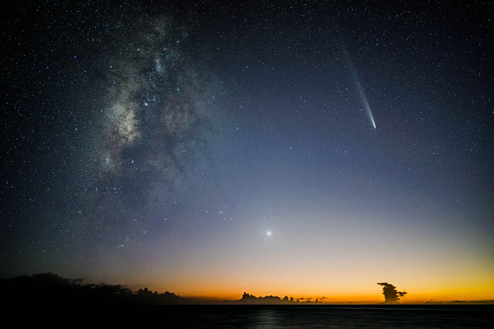 Comet and Milky Way over the sea